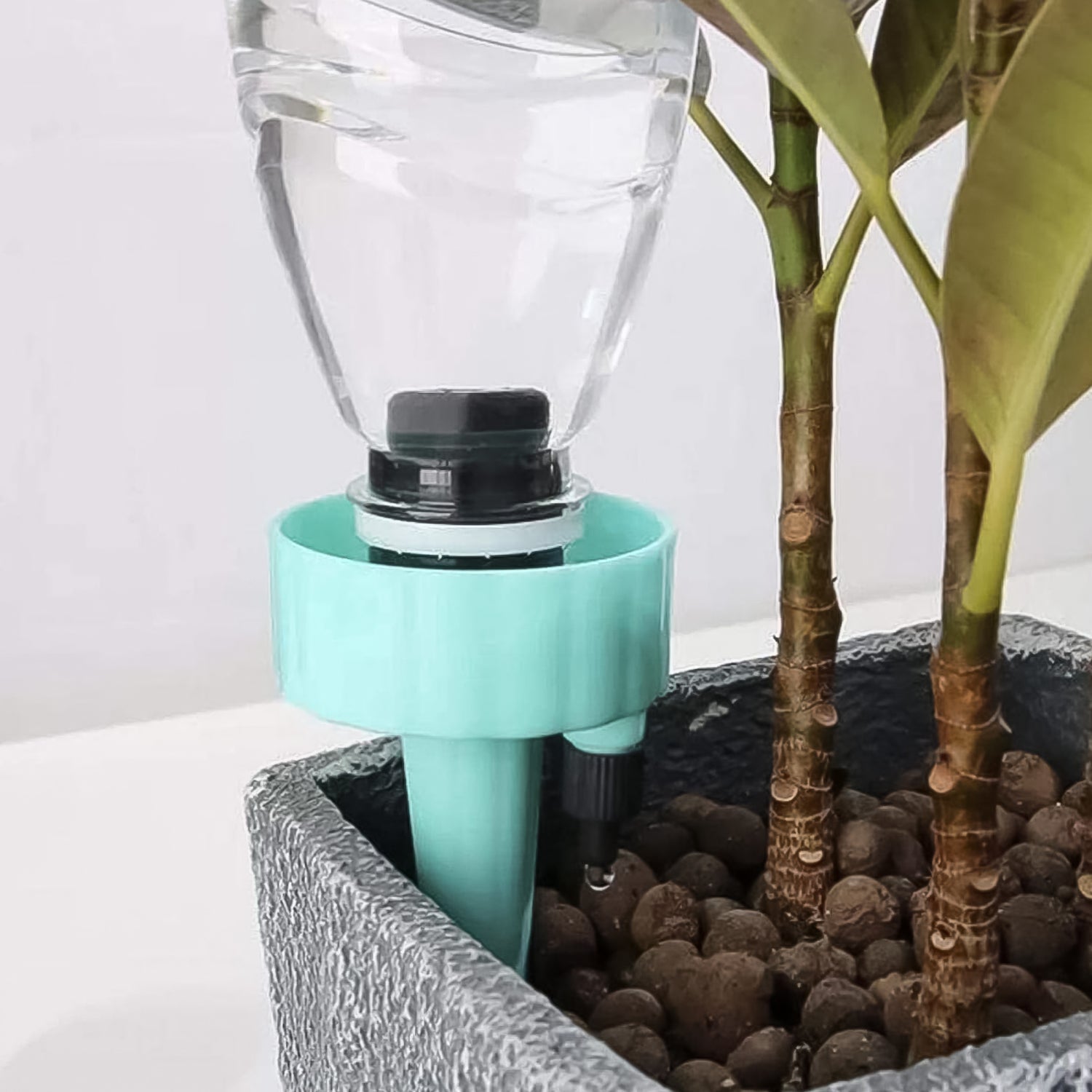A self-watering spike inserted into a potted plant, demonstrating its discreet and effective use.
