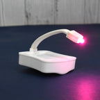 Hand holding the battery-operated LED toilet light, highlighting its portable design.
