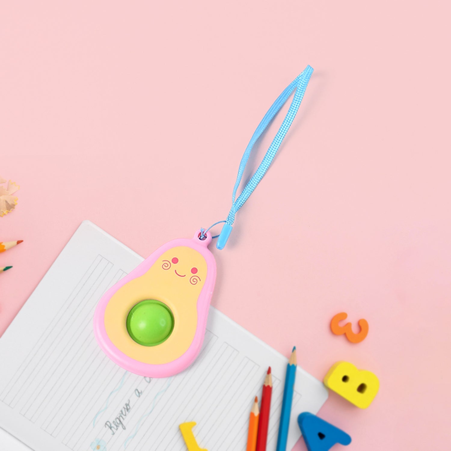 Cute avocado-shaped mini push pop keychain with strap on bag
