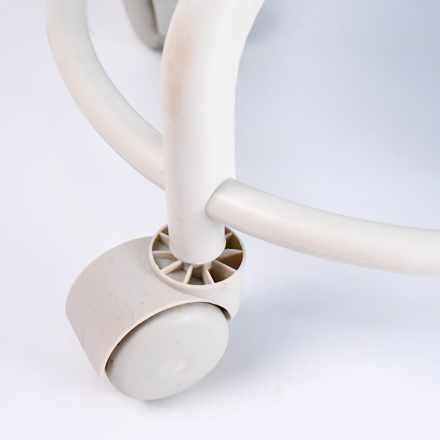 Side view of low rolling stool showing cushioned seat and sturdy wheels