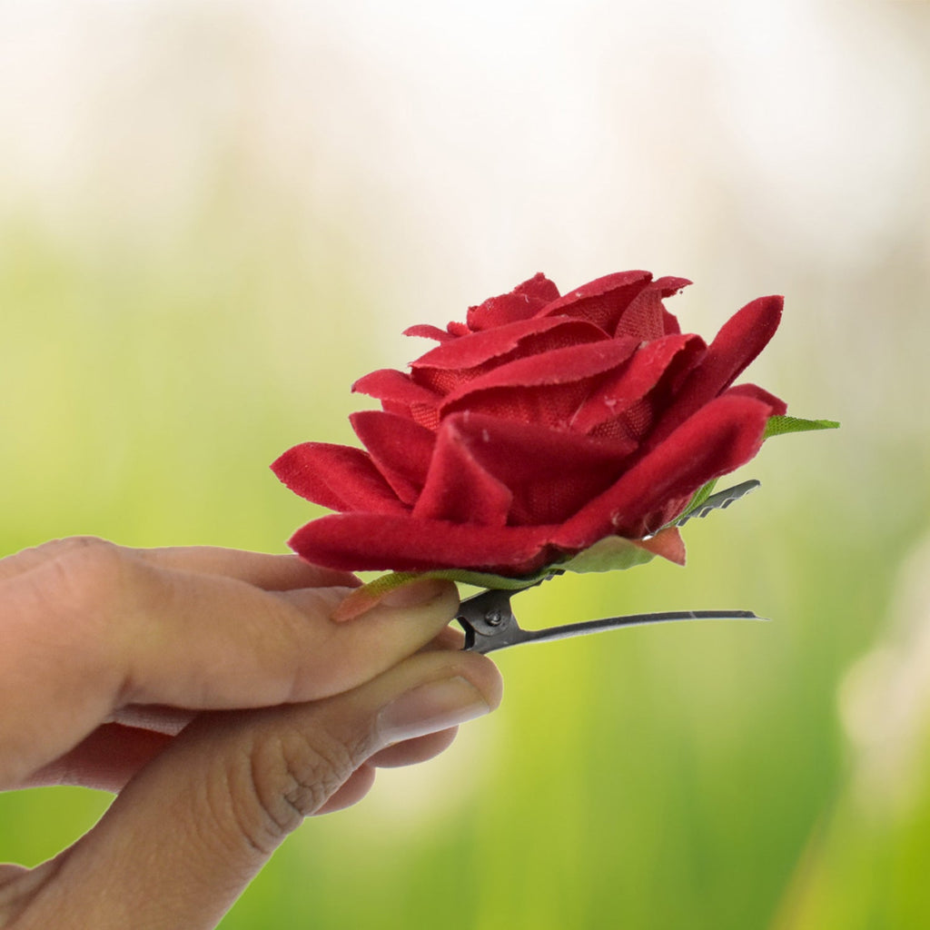 A set of red velvet rose hair clips artfully arranged, highlighting their rich texture.