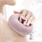 A hand holding the flower-shaped bath sponge during a refreshing shower.