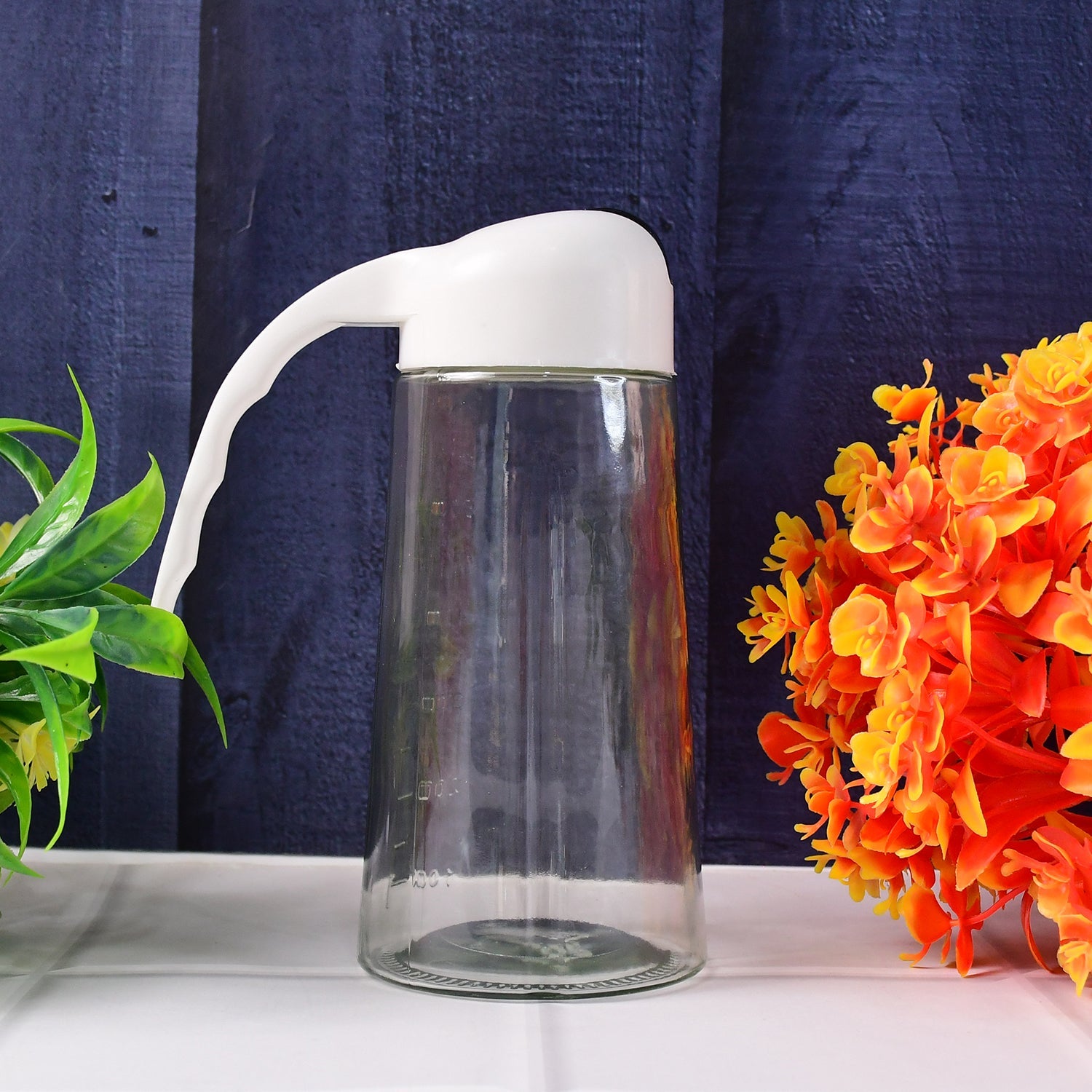 Glass oil bottle dispenser standing upright with closed automatic lid