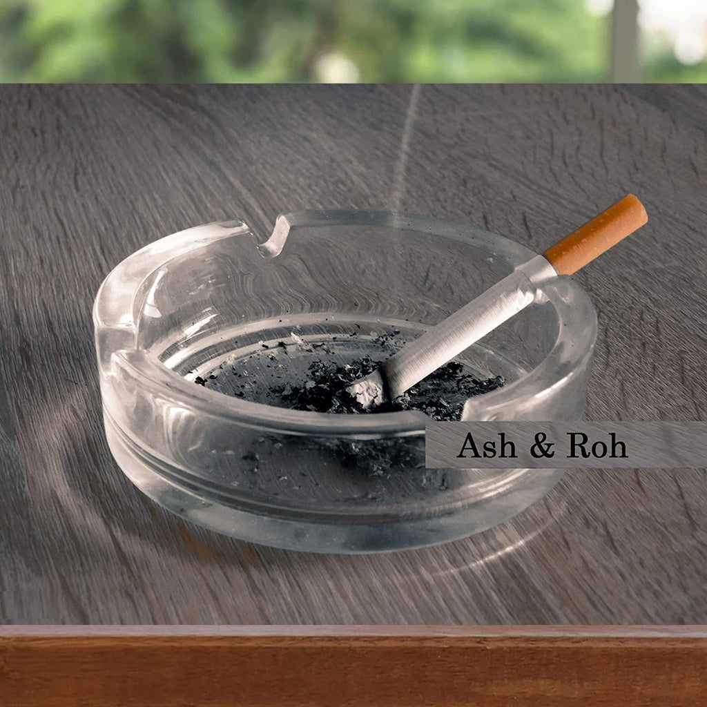 This round crystal glass ashtray features four slots for cigars and cigarettes.