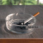 This round crystal glass ashtray features four slots for cigars and cigarettes.
