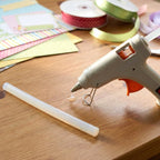 Hot glue stick inserted into a glue gun for precise adhesive application
