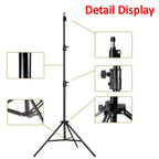 Artist setting up an adjustable metal easel for painting outdoors.