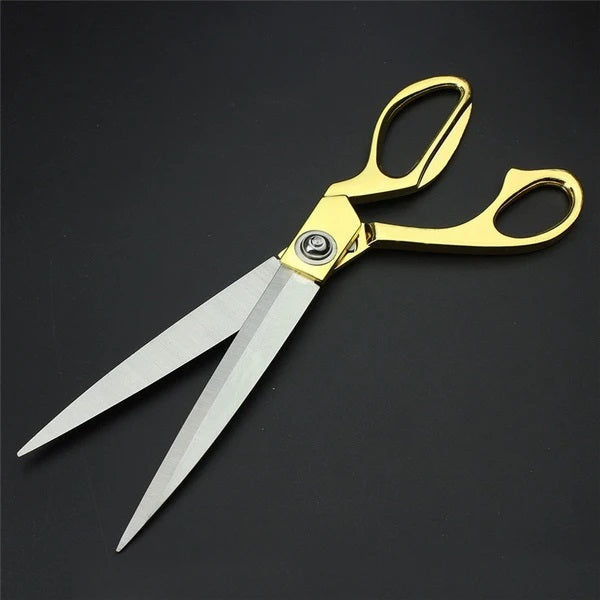 Professional golden scissors demonstrating sharp cloth cutting capability.