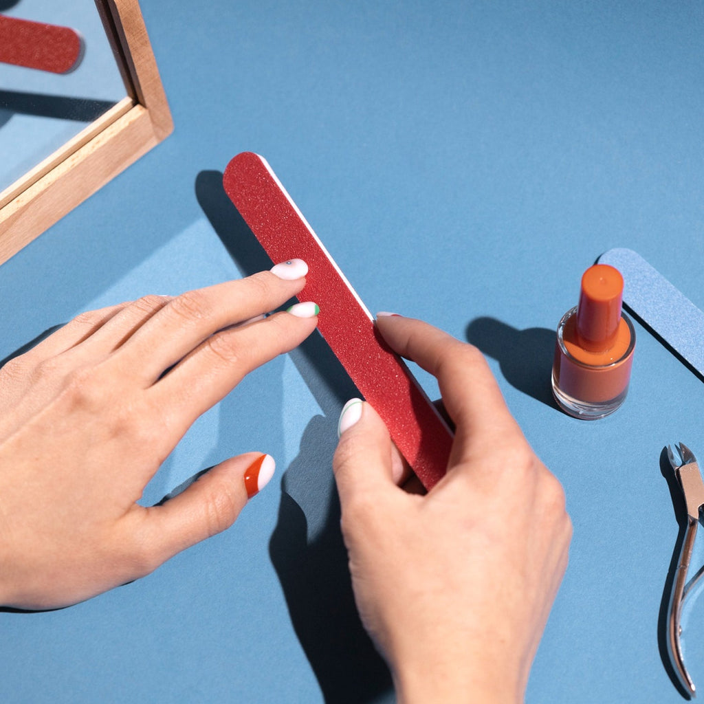 Woman using professional nail file to shape fingernails