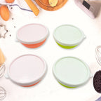 Four small plastic bowls with lids on a modern kitchen counter.