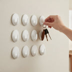 White adhesive wall hooks used for organizing bags and accessories