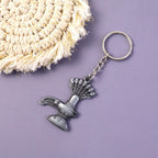 Close-up view of metal Shiva Lingam and Naag symbol on keychain