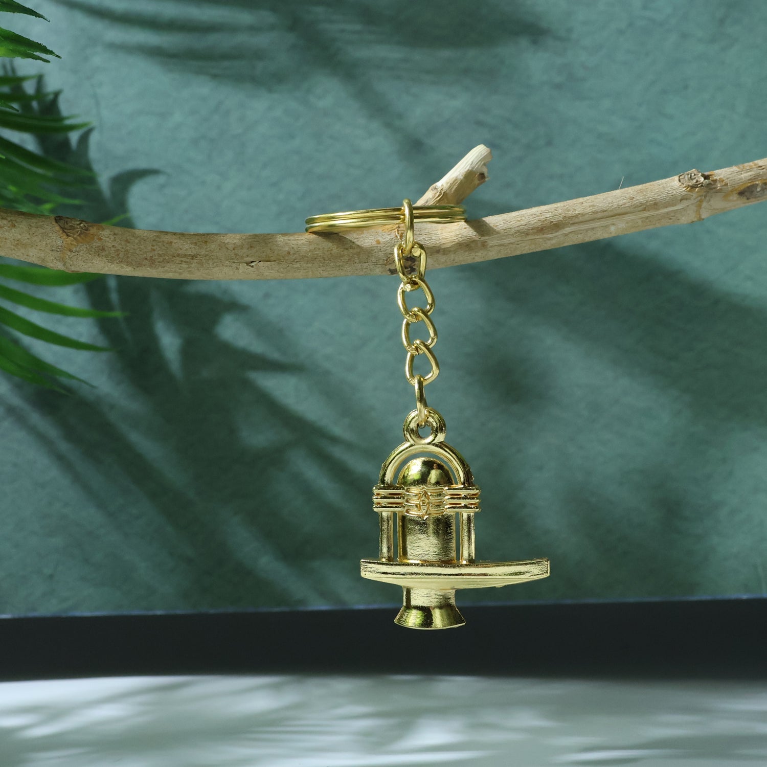 Intricate details of the golden Shivling metal keychain emphasizing religious symbolism