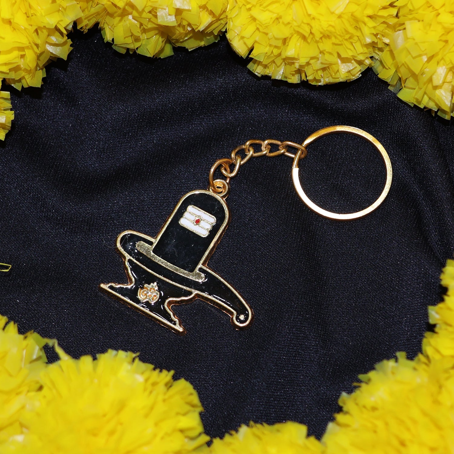 Hand holding golden Shivling keychain showing its size and golden finish