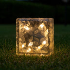Three solar garden lights arranged artistically on a stone path.