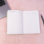 Open hardbound diary notebook prepared for writing notes