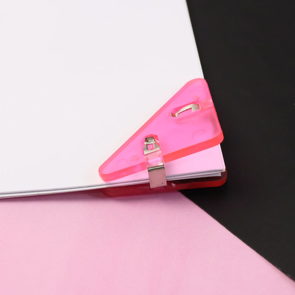 Close-up of durable triangle paper clip securing paper corner