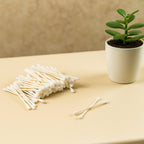 Side view of soft, tightly wound cotton tips on paper sticks.