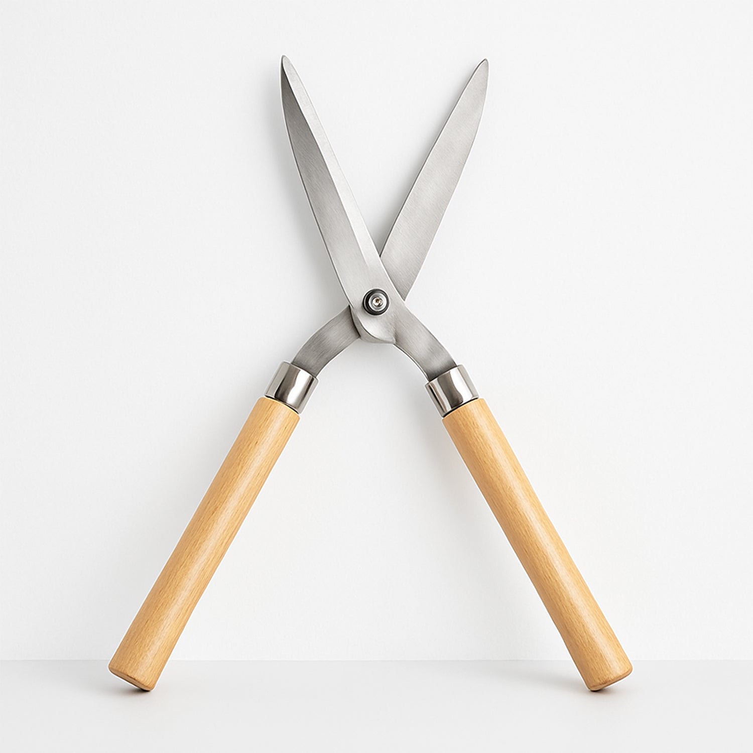 Angled view of the Indo Glow Hedge Shears, highlighting both the wooden handles and the sharp steel blades.