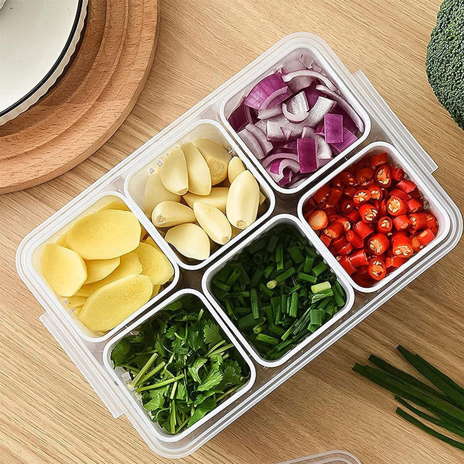 A fridge storage box filled with fresh produce placed inside a clean refrigerator.