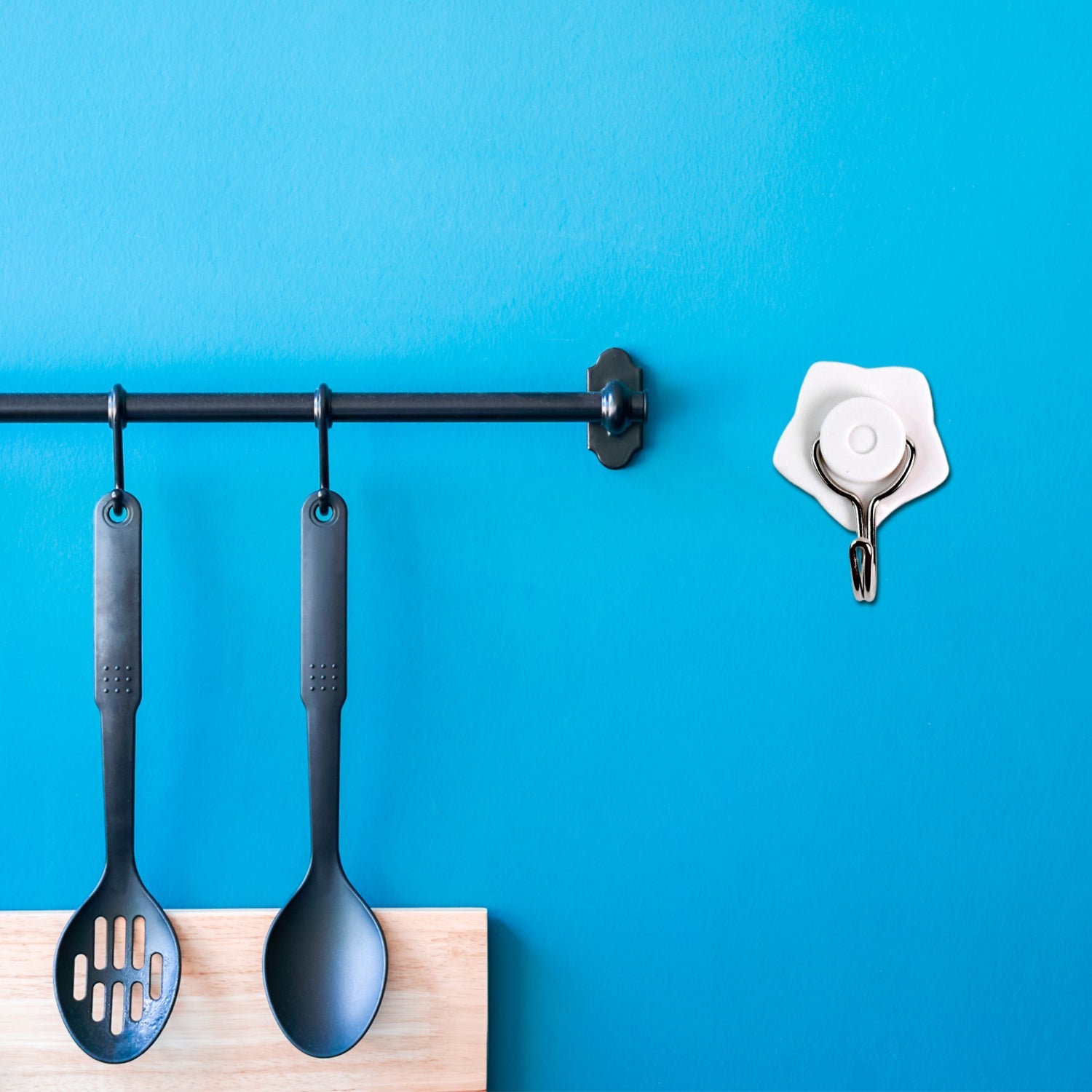 Six vibrant, self-adhesive hooks in their retail packaging, ready for home organization.