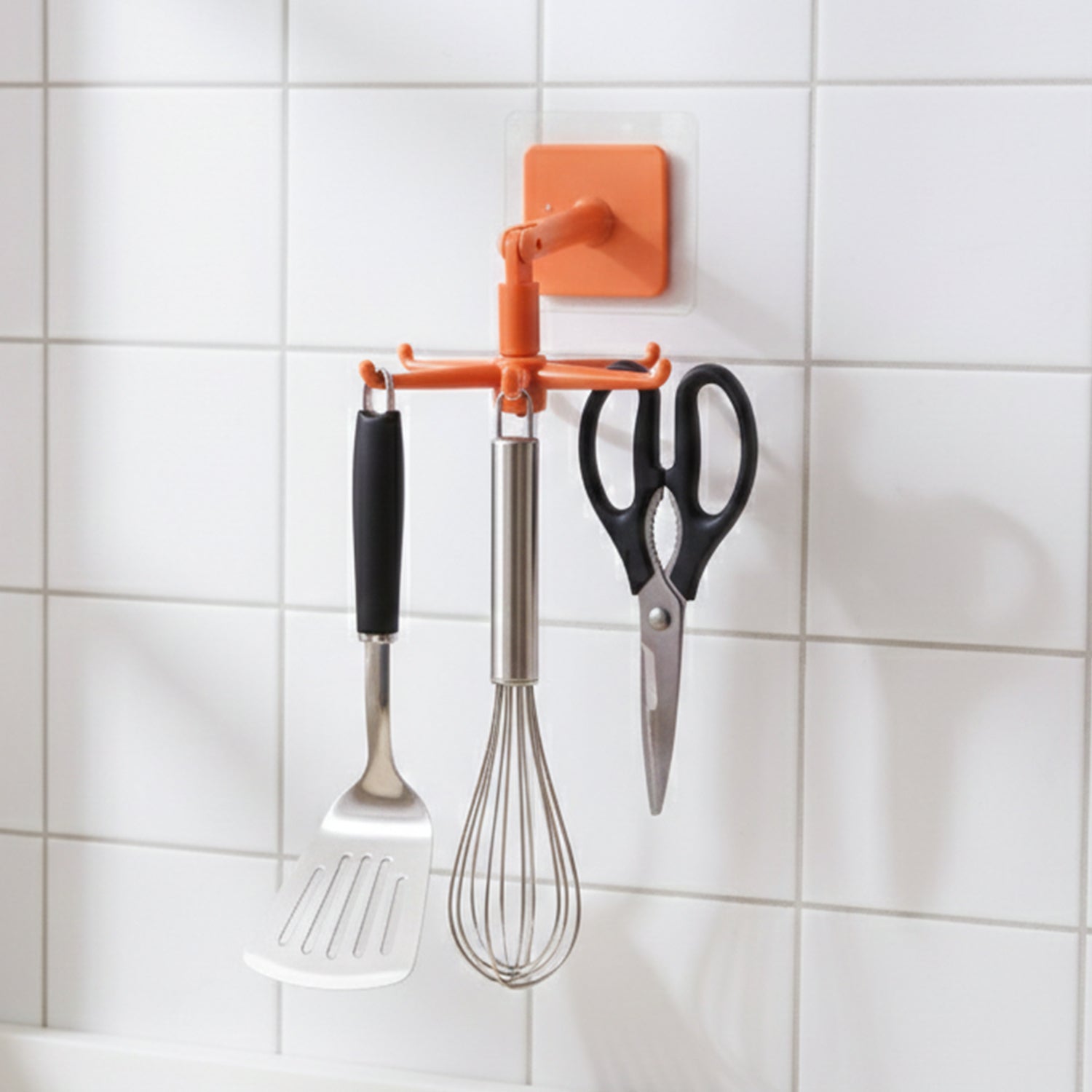 Orange rotating kitchen utensils hook stand mounted on kitchen wall
