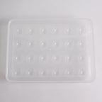 Clear plastic egg container next to traditional egg carton for size comparison