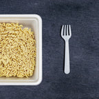 Stack of Quickslice disposable plastic forks and spoons against a clean backdrop.