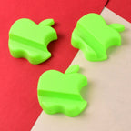 Three apple-shaped smartphone stands in mixed colors held on a tabletop