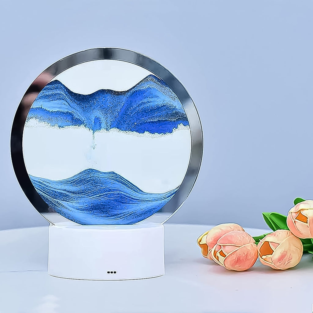 The Moving Sand Art Picture acting as a unique table lamp with its colored light base.