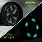 A car's wheel hub decorated with bright multicolored reflective stickers during the day.