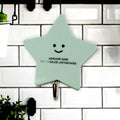 A set of strong self-adhesive hooks displayed neatly on a tiled kitchen wall, ready for use.