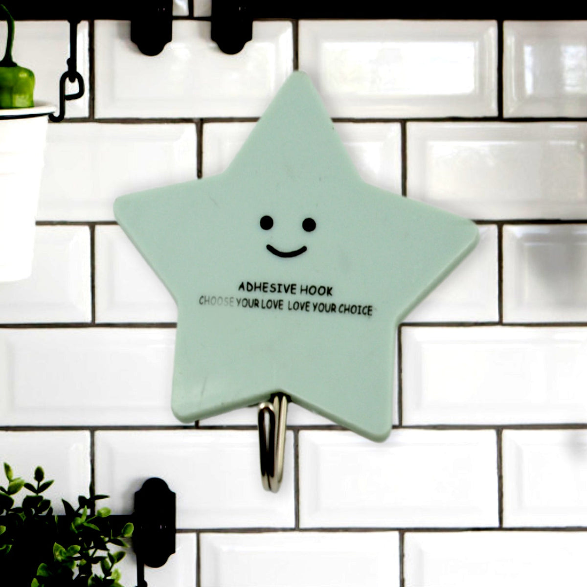 A set of strong self-adhesive hooks displayed neatly on a tiled kitchen wall, ready for use.