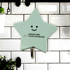 A set of strong self-adhesive hooks displayed neatly on a tiled kitchen wall, ready for use.