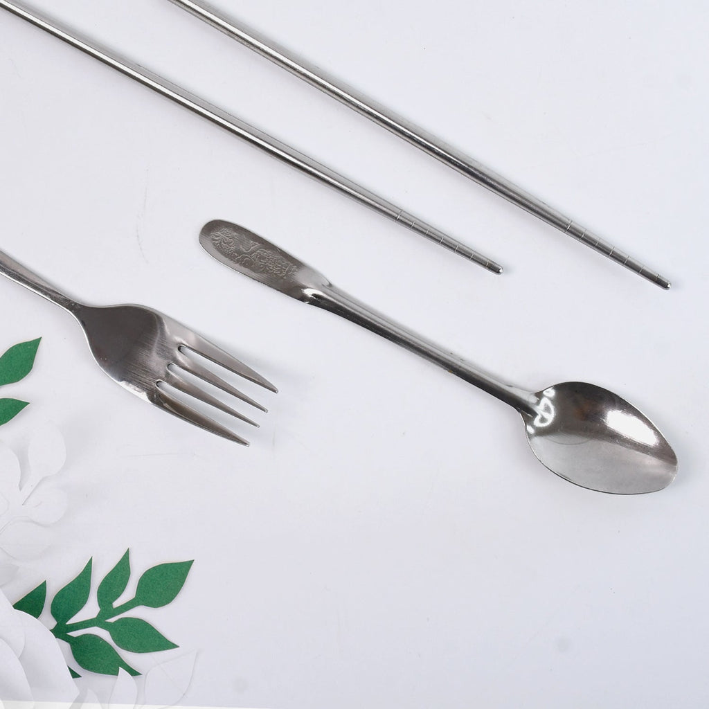 Hand holding compact portable stainless steel cutlery set demonstrating size