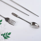 Hand holding compact portable stainless steel cutlery set demonstrating size