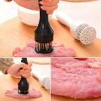 Stainless steel meat tenderizer tool with multiple sharp needles, shown in use.