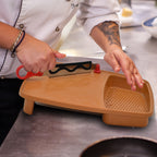 Close-up of the cutting board showing its thick plastic construction and ergonomic holder.