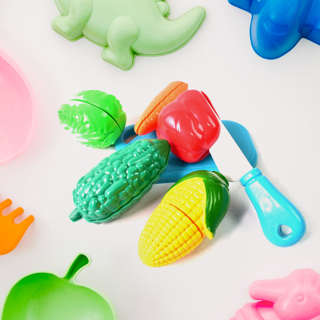 Child's hands slicing a toy banana on a cutting board from the Slice & Play Toy Set.