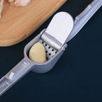 Aluminum garlic press on a kitchen counter, ready for use.