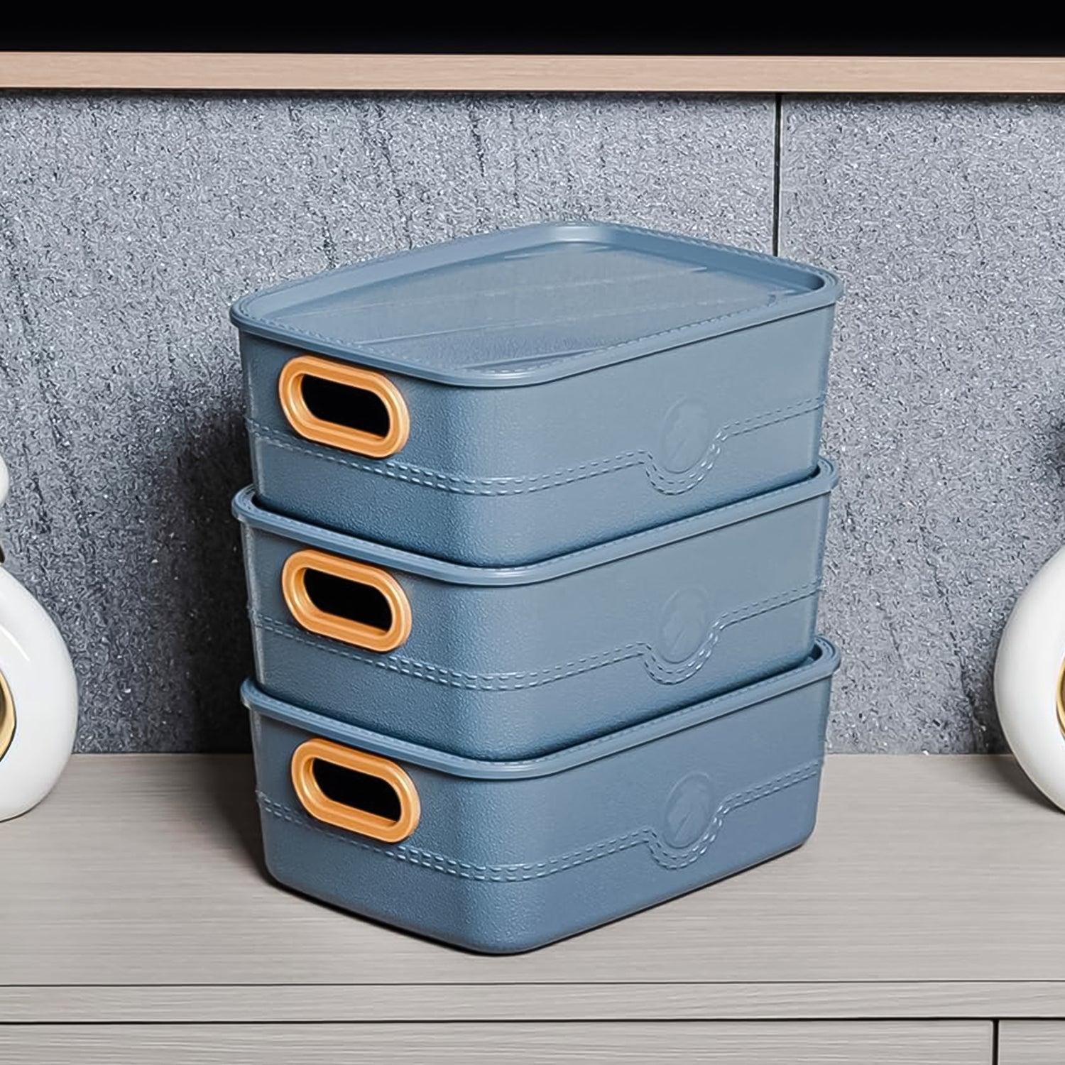 Three colorful plastic storage baskets with handle cutouts