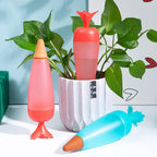 Group of colorful carrot-design automatic plant watering globes ready for use.