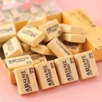 Several yellow 4B erasers scattered on a desk, showcasing their bulk quantity.