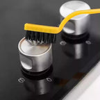 Mini nylon cleaning brush effectively scrubbing a dirty surface.