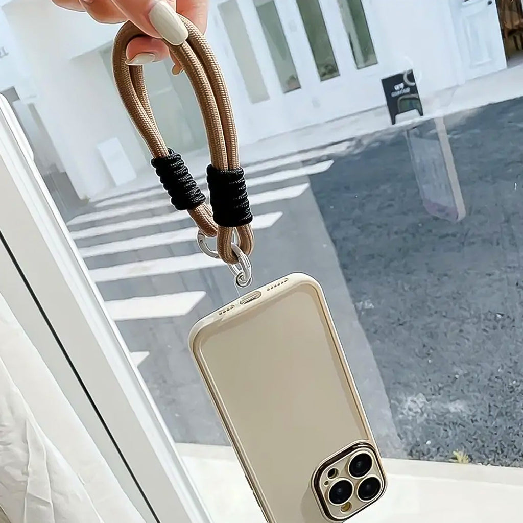 Various daily essentials like keys, USB drives, and a phone, all secured by the versatile phone wrist strap.