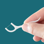 Close-up of a MintGuard Portable Dental Floss Pick showing its dual toothpick and floss ends.