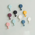 Pack of 10 transparent self-adhesive wall hooks on a white surface.
