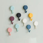 Pack of 10 transparent self-adhesive wall hooks on a white surface.