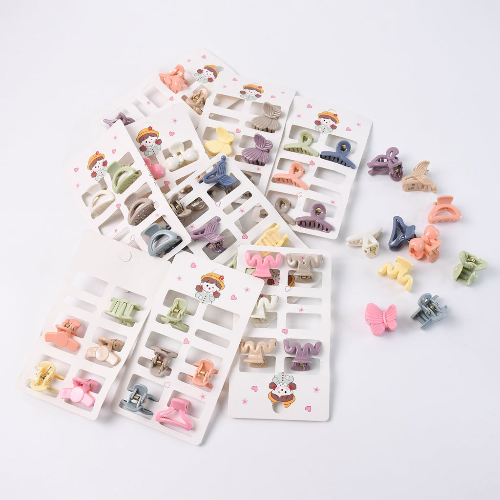 Neatly arranged collection of multicolour mini claw clips for girls on a white background.