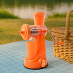 Fresh orange juice being made with the Manual Fruit Juicer, surrounded by oranges.